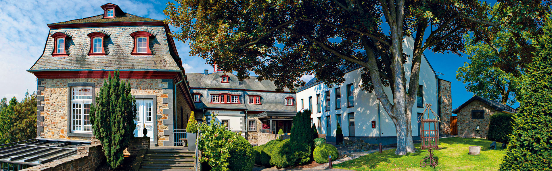 Schloss Burgbrohl. Vier-Sterne-Wellnesshotel. Sommer im Schloss. Ansicht aus Schlosspark.