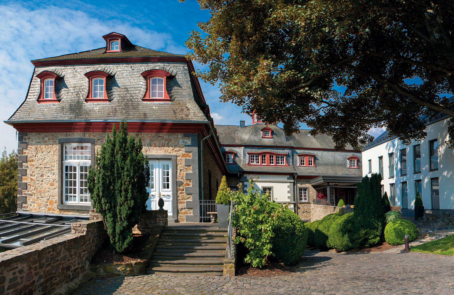 Sicht auf Schloss und Spa Haus aus Schloss Park. Schloss Burgbrohl. Vier Sterne Wellnesshotel.